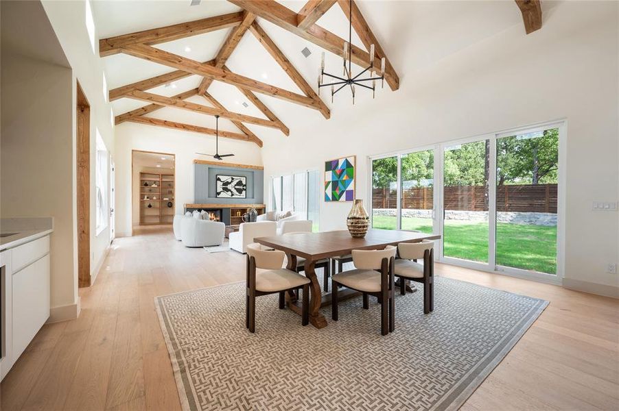 Dining area with light hardwood / wood-style flooring, plenty of natural light, and high vaulted ceiling