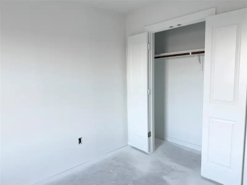 Unfurnished bedroom featuring concrete floors and a closet Unfurnished bedroom featuring concrete floors and a closet
