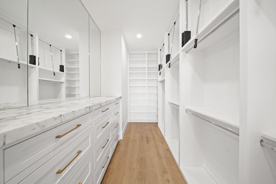 The second oversized closet in the primary suite with custom cabinetry, custom drawers, and pull downs for those hard to reach shelves. The second oversized closet in the primary suite with custom cabinetry, custom drawers, and pull downs for those hard to reach shelves.