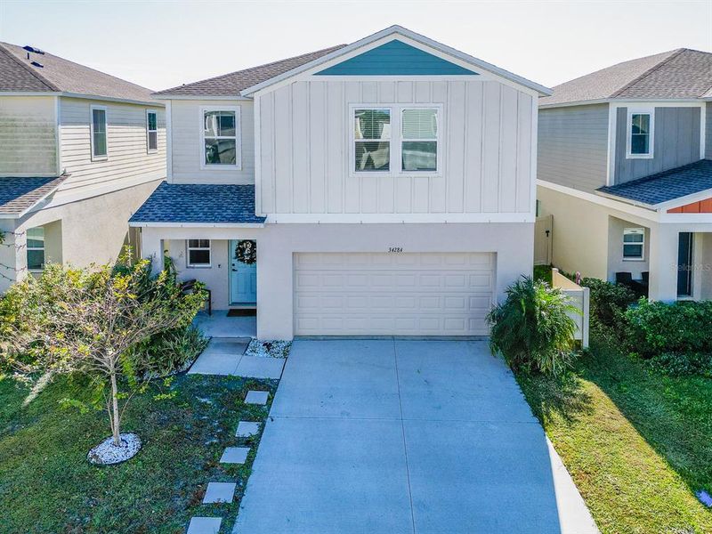 Front exterior of a new home in Pasadena Point, Wesley Chapel, FL, highlighting curb appeal (Image 25). Front exterior of a new home in Pasadena Point, Wesley Chapel, FL, highlighting curb appeal (Image 25).