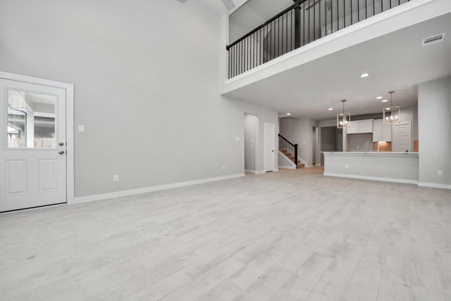 Bring your loved ones and guests together in the inviting living room! Boasting lofty high ceilings, recessed lighting, a stylish ceiling fan, custom paint, stunning flooring, and expansive windows that flood the space with ample natural light all day long.