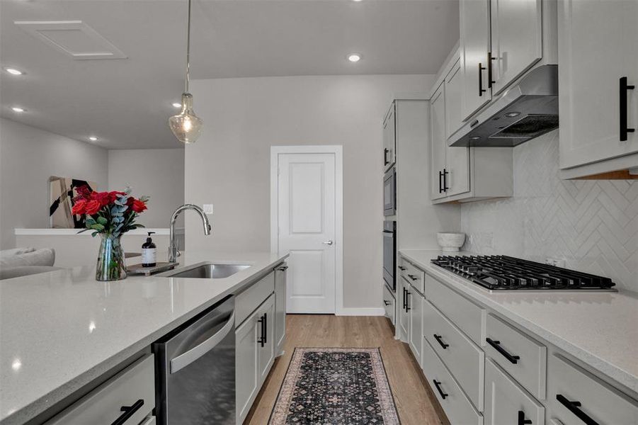 Features under cabinet lighting, quartz countertop, gas cooktop, stainless steel appliances, and walk-in pantry. Features under cabinet lighting, quartz countertop, gas cooktop, stainless steel appliances, and walk-in pantry.