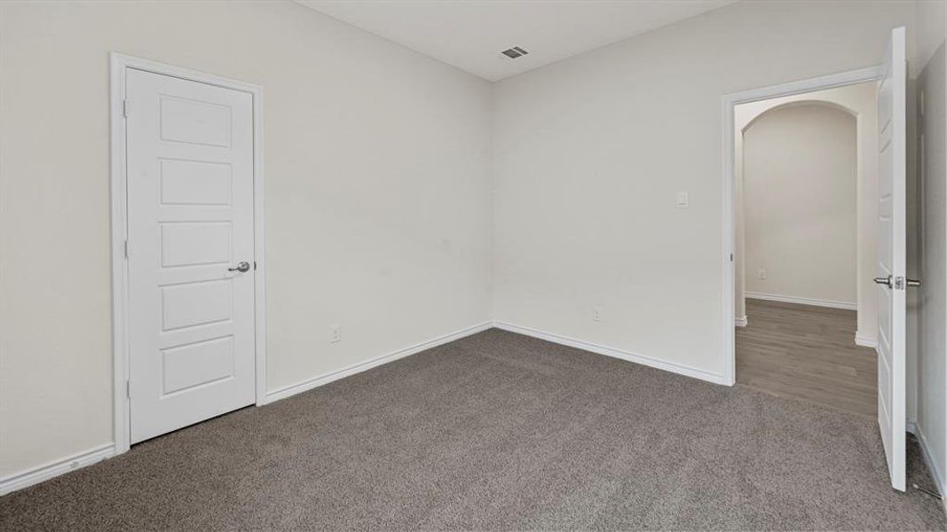 Neutral tone paint throughout, featuring gray carpet flooring and white baseboards