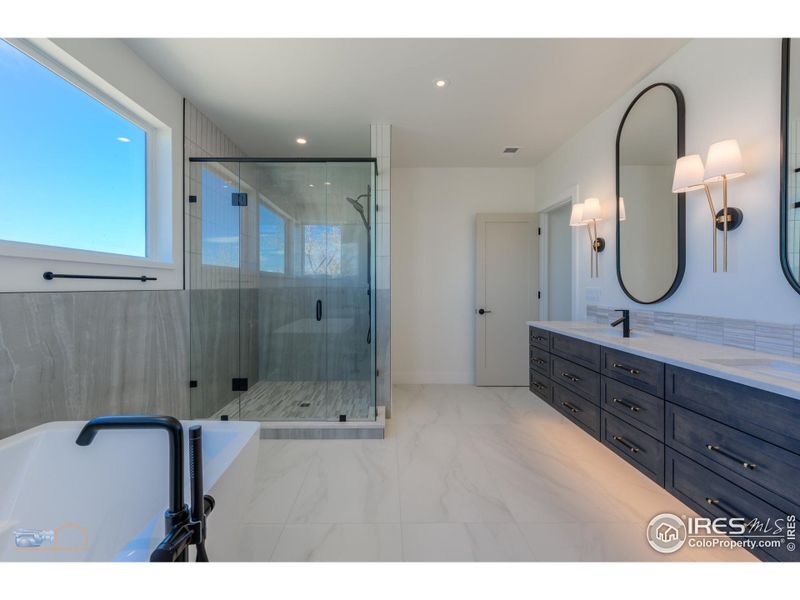 Luxurious Primary Bath Features A Bain Ultra Soaking Tub, Large Shower, Double Vanities, Grohe Faucets, Private Commode & Heated Tile Floor
