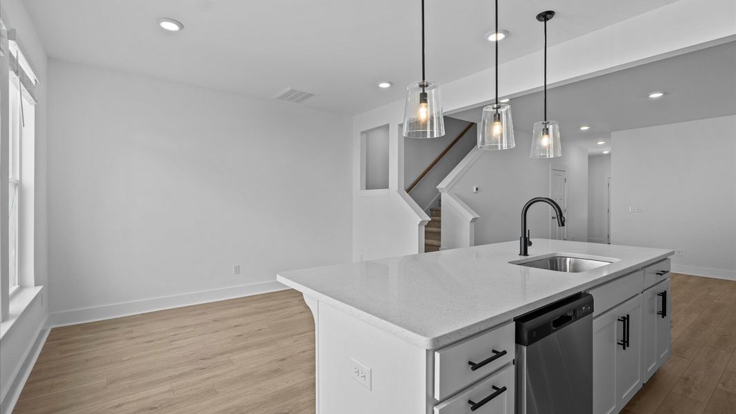 Tasteful design meets functional luxury in this kitchen with a 9-foot island and modern pendant lighting Tasteful design meets functional luxury in this kitchen with a 9-foot island and modern pendant lighting