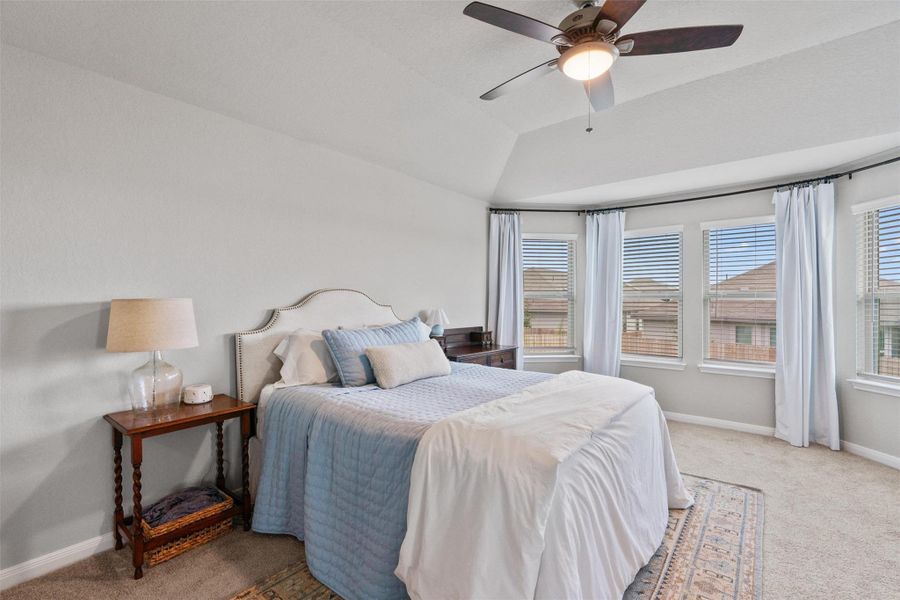 Bedroom with a vaulted ceiling and a ceiling fan Bedroom with a vaulted ceiling and a ceiling fan