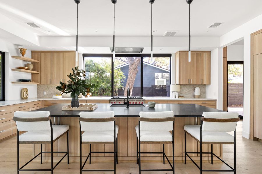 Kitchen with light wood finished floors, backsplash, light brown cabinetry, a center island with sink, and recessed lighting Kitchen with light wood finished floors, backsplash, light brown cabinetry, a center island with sink, and recessed lighting