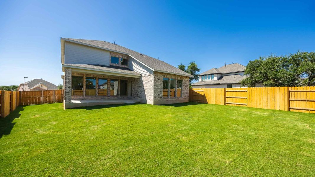 Back of house featuring brick siding and a fenced backyard Back of house featuring brick siding and a fenced backyard