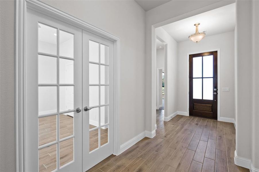 Entrance foyer with light wood-style floors and french doors Entrance foyer with light wood-style floors and french doors