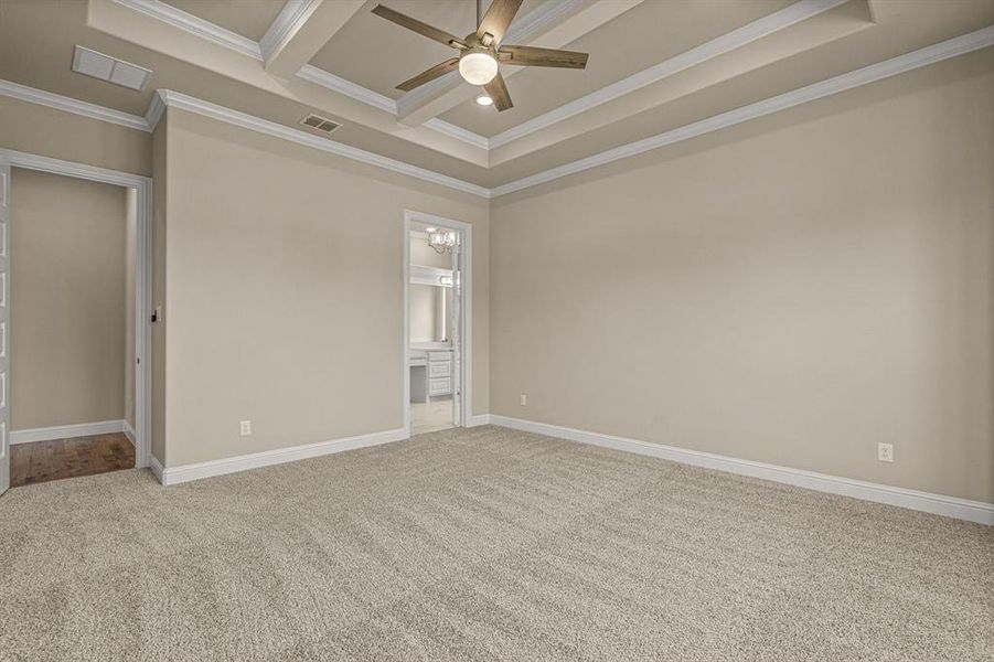 Unfurnished room with ceiling fan, carpet flooring, crown molding, and a tray ceiling