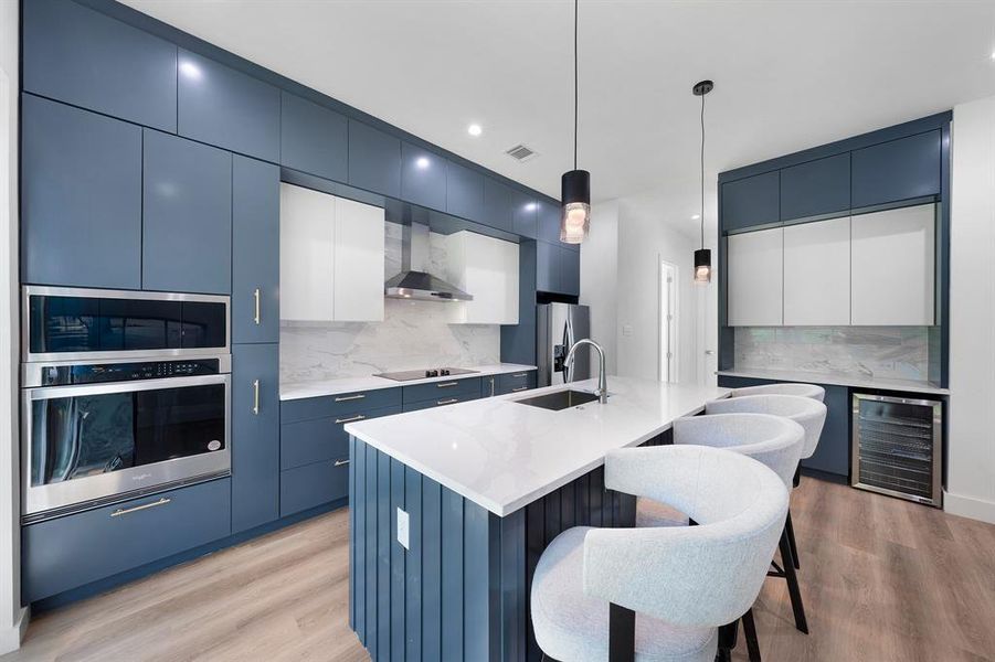 Kitchen featuring blue cabinetry, modern cabinets, a kitchen island with sink, and recessed lighting Kitchen featuring blue cabinetry, modern cabinets, a kitchen island with sink, and recessed lighting