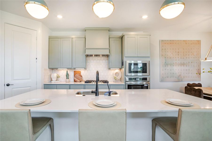 This modern kitchen features sleek cabinetry, a stylish hexagon tile backsplash, and stainless steel appliances. The spacious island with seating is perfect for casual dining and entertaining. Bright lighting and clean design create an inviting atmosphere. This modern kitchen features sleek cabinetry, a stylish hexagon tile backsplash, and stainless steel appliances. The spacious island with seating is perfect for casual dining and entertaining. Bright lighting and clean design create an inviting atmosphere.