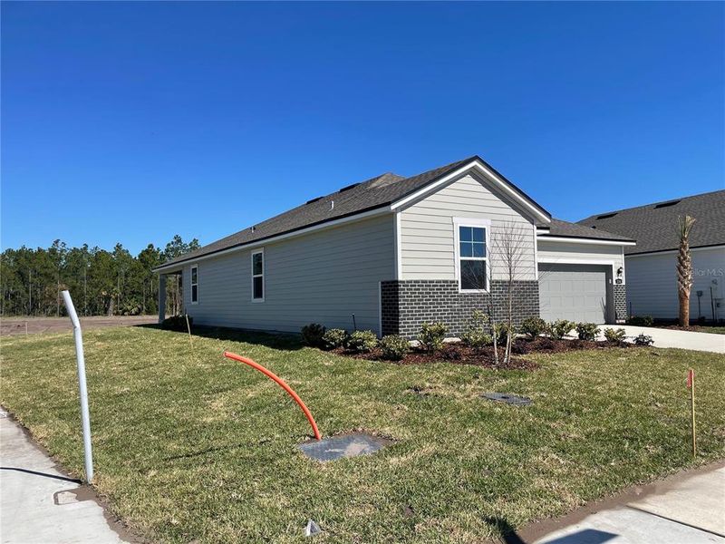 Front exterior of a new home in Magnolia Series at Seminole Palms, Palm Coast, FL, highlighting curb appeal (Image 2). Front exterior of a new home in Magnolia Series at Seminole Palms, Palm Coast, FL, highlighting curb appeal (Image 2).