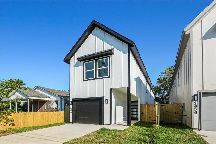 View of front facade with board and batten siding, a gate, a garage, and concrete driveway View of front facade with board and batten siding, a gate, a garage, and concrete driveway