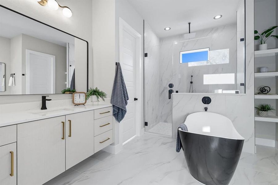 Full bathroom featuring vanity, a marble finish shower, a freestanding tub, light marble finish flooring, and recessed lighting Full bathroom featuring vanity, a marble finish shower, a freestanding tub, light marble finish flooring, and recessed lighting