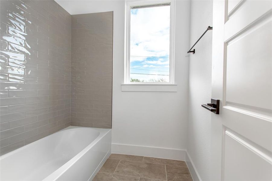 Bathroom with tile patterned flooring and tiled shower / bath combo