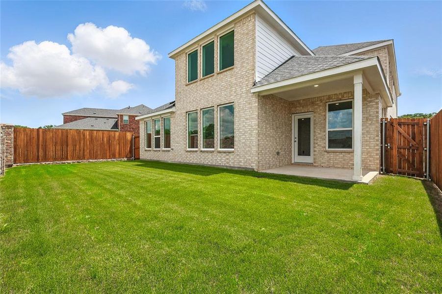 Back of property with a patio area, a fenced backyard, brick siding, and roof with shingles Back of property with a patio area, a fenced backyard, brick siding, and roof with shingles