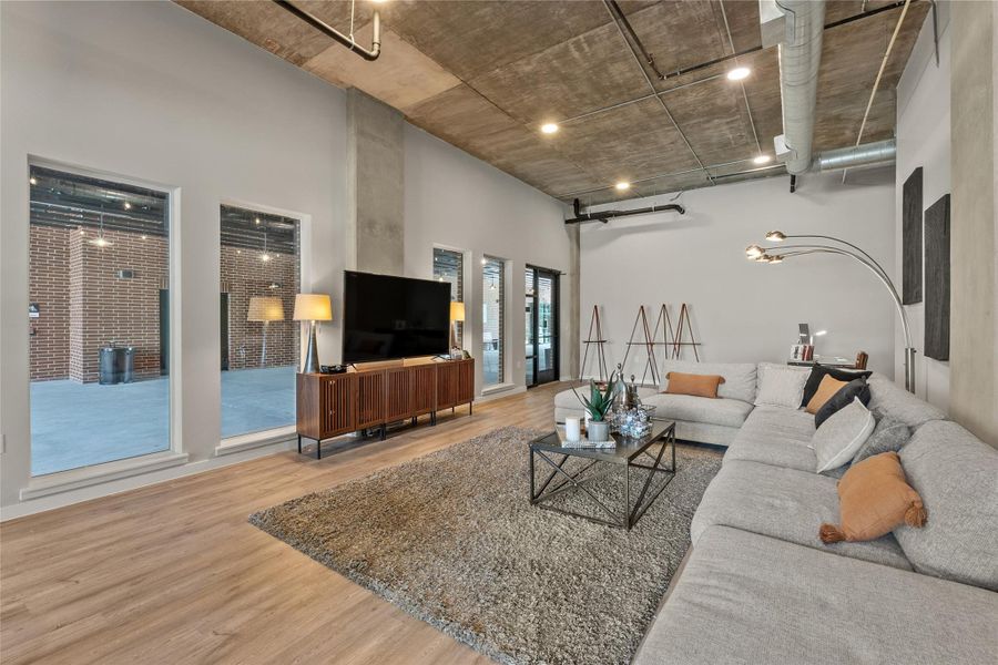 Living room with wood finished floors, a high ceiling, and a barn door