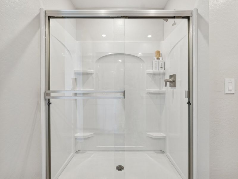 A glass shower with a glass door.