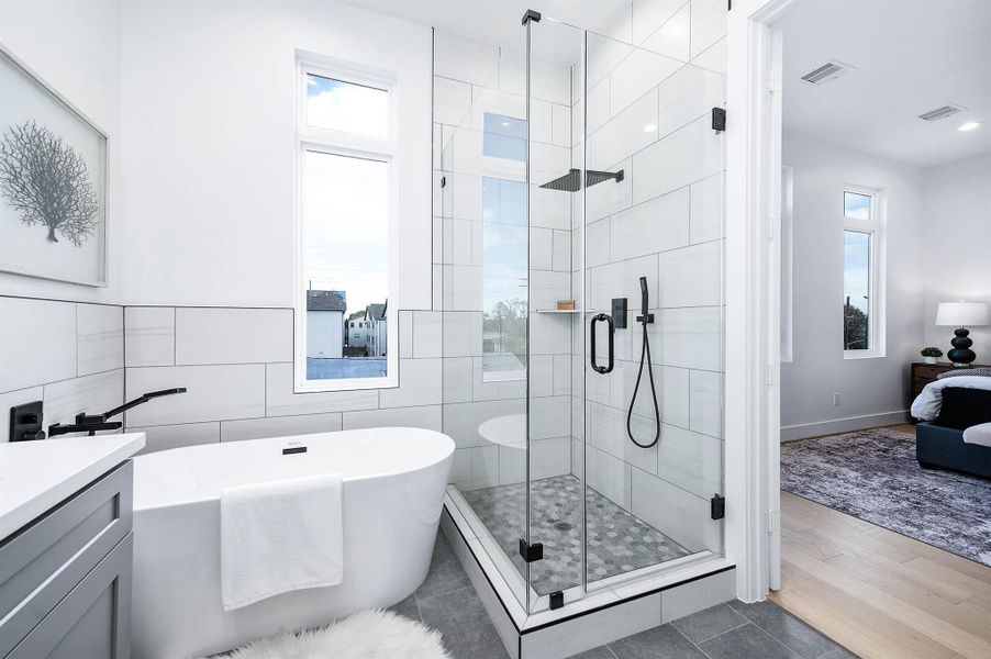 Elegant primary bathroom with dual vanity, soaking tub and large glass shower. Elegant primary bathroom with dual vanity, soaking tub and large glass shower.