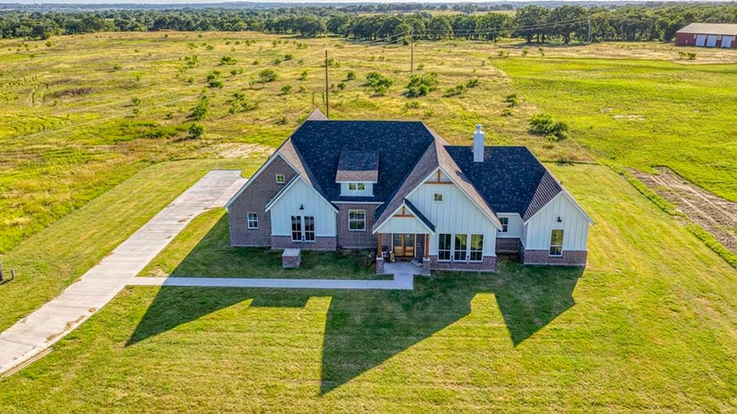 Front exterior of a new home in Oak Water Ranch, Granbury, TX, highlighting curb appeal (Image 23). Front exterior of a new home in Oak Water Ranch, Granbury, TX, highlighting curb appeal (Image 23).
