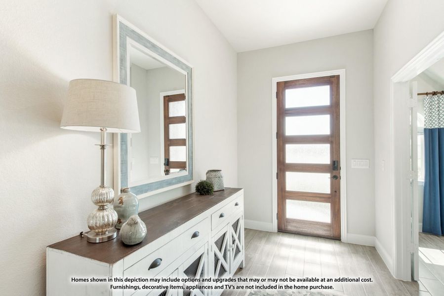 Entryway with wood and glass front door, white console table, large mirror, and light gray walls