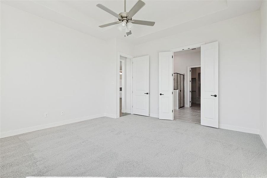 Unfurnished bedroom with ceiling fan and light colored carpet