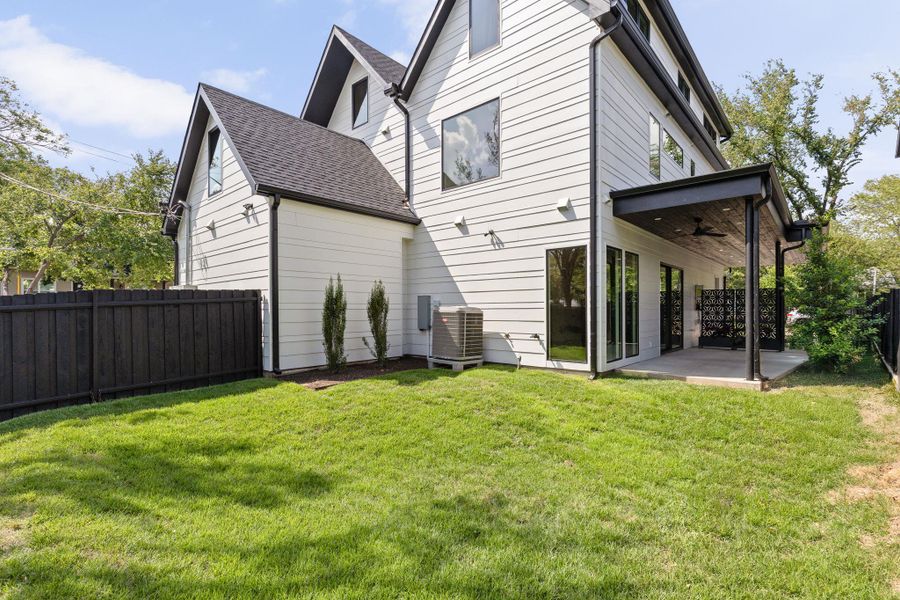 Rear view of house featuring a ceiling fan, a patio, a fenced backyard, and roof with shingles