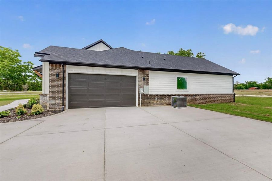 Concrete driveway leading to a two-car garage with a paneled door