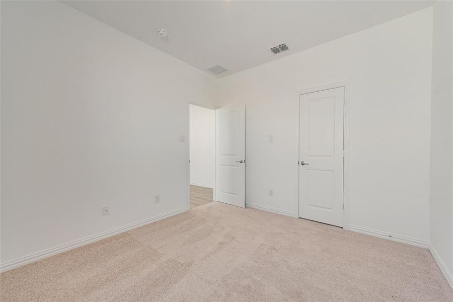 Empty room with light colored carpet