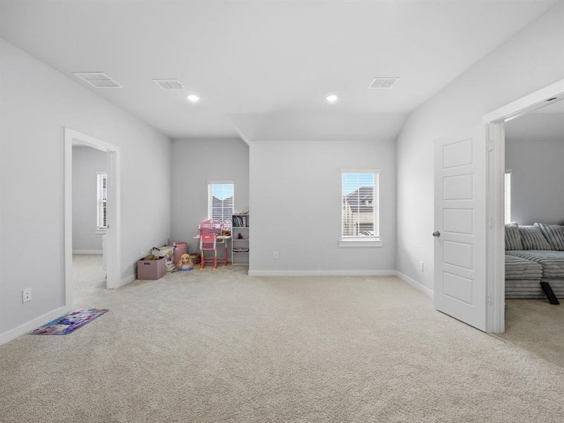 Rec room with light colored carpet, plenty of natural light, and recessed lighting