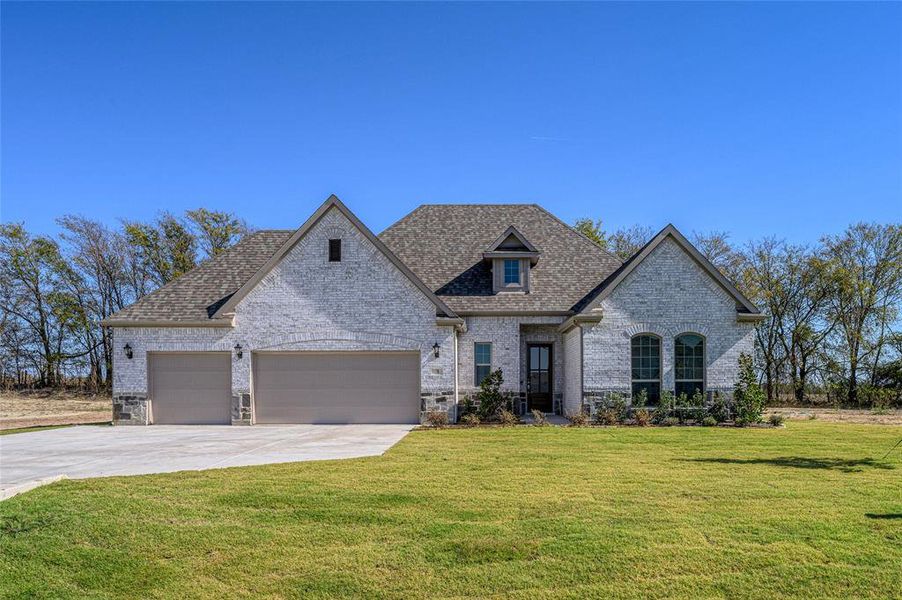 French provincial home with a front lawn, brick siding, driveway, an attached garage, and a shingled roof French provincial home with a front lawn, brick siding, driveway, an attached garage, and a shingled roof