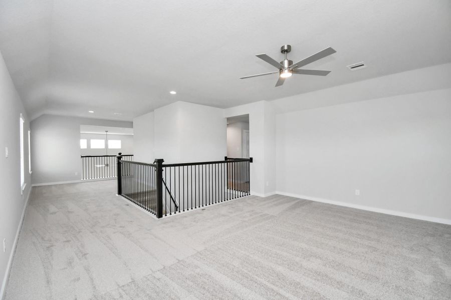 Come upstairs and relish a day of relaxation in this loft area! Ideal as an additional living space or game room, it boasts plush carpeting, high ceilings, custom paint, and windows that flood the area with abundant natural light. Sample photo of completed home with similar floor plan. Actual colors and selections may vary.