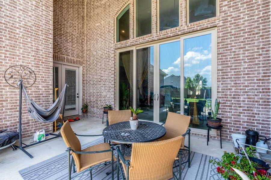 Wooden terrace with a fenced backyard, a trampoline, and a patio