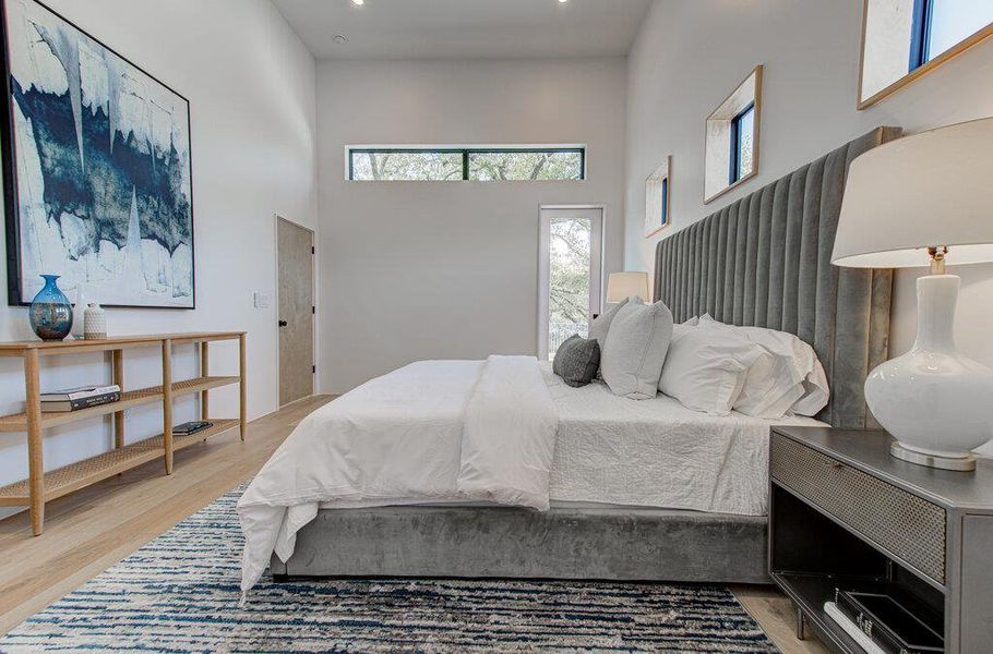 Bedroom with light wood-style flooring and a high ceiling