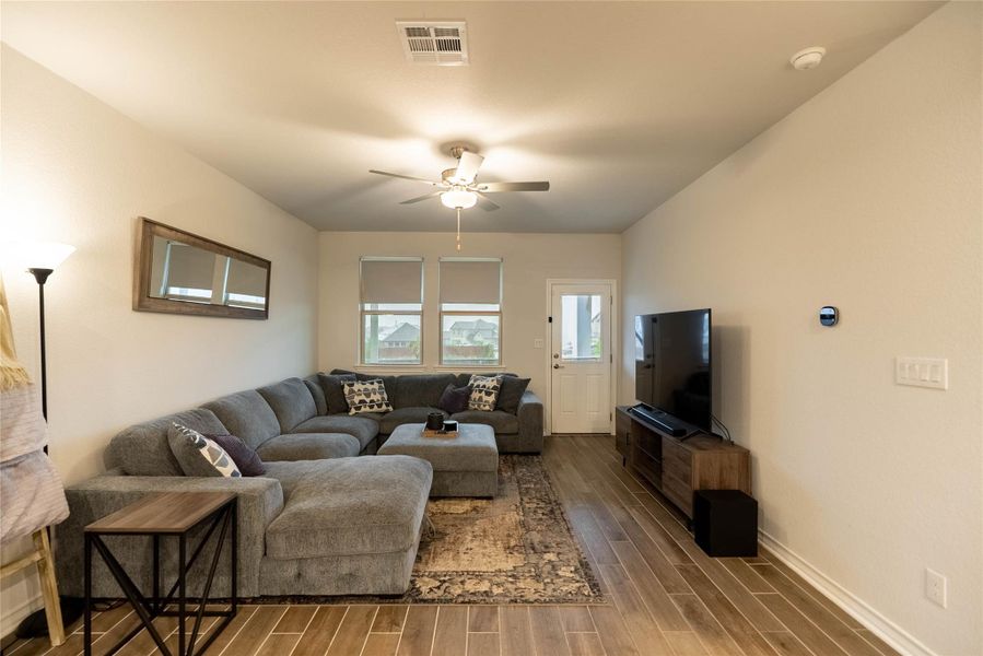 Living area featuring wood finished floors and a ceiling fan Living area featuring wood finished floors and a ceiling fan