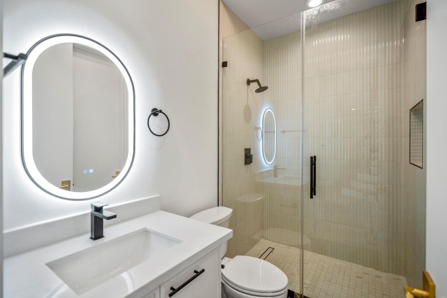 Guest Bathroom with full shower glass enclosure. This beige color tile gives a warm inviting spa like feel while the vertical tile design provides modern look. Guest Bathroom with full shower glass enclosure. This beige color tile gives a warm inviting spa like feel while the vertical tile design provides modern look.