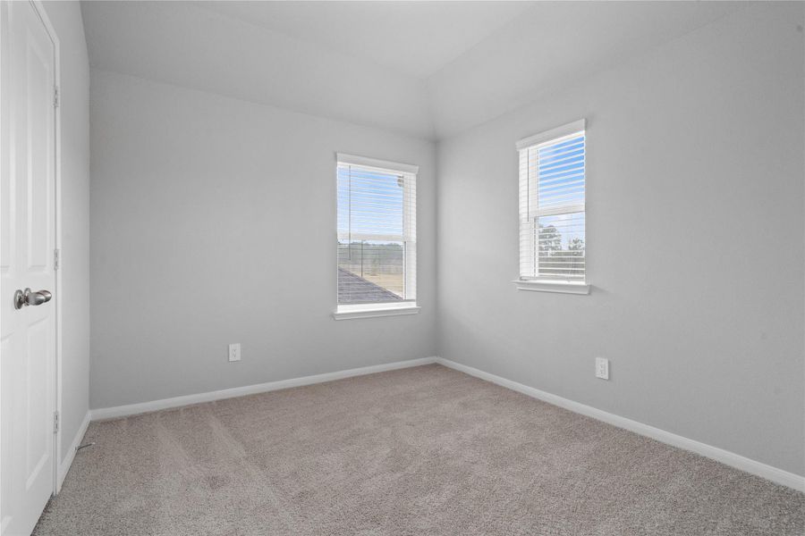 An additional secondary bedroom with large windows (fitted wth blinds), plush carpet flooring, and ample sized closet space to suit family or guests a comfortable place to stay.