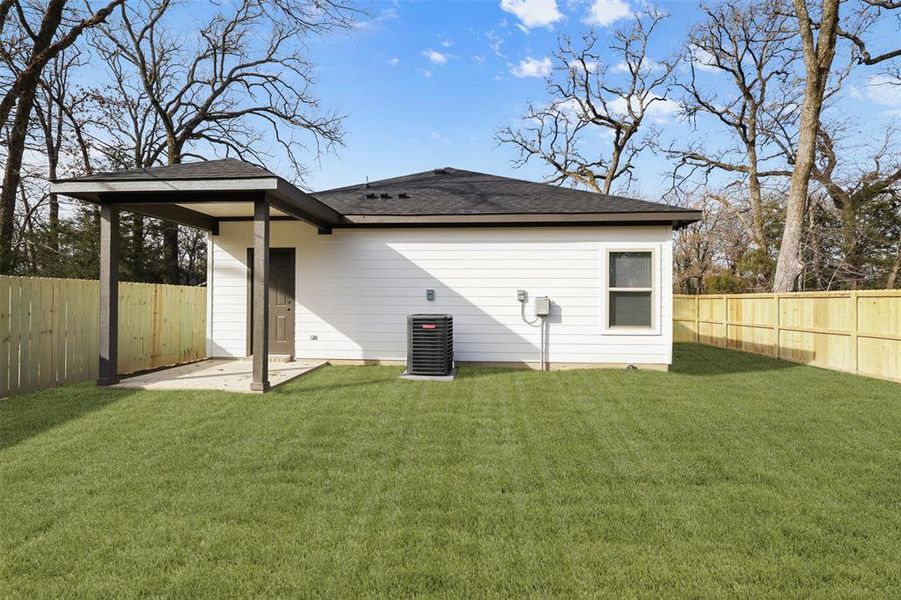 Back of property featuring central AC unit, a patio, and a yard