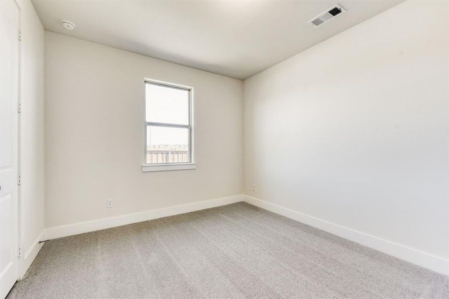 Empty room featuring light colored carpet and baseboards