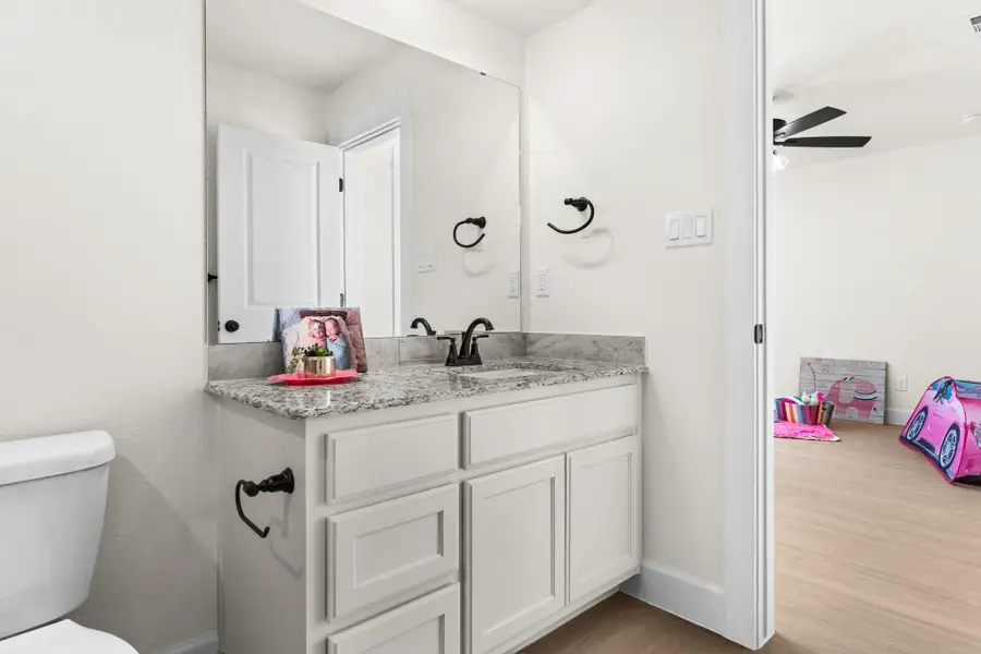 Bathroom featuring vanity, light wood-style flooring, and a ceiling fan