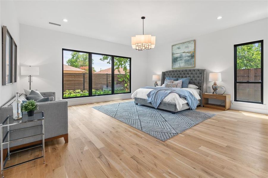 Bedroom featuring light wood-type flooring and an inviting chandelier