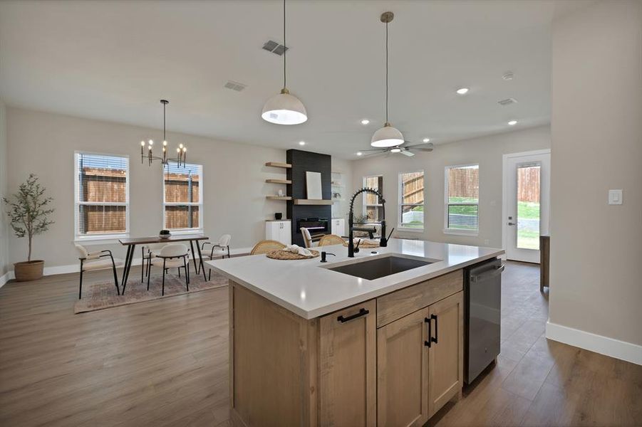 Kitchen featuring a sink, dishwasher, light wood-style floors, light countertops, and baseboards Kitchen featuring a sink, dishwasher, light wood-style floors, light countertops, and baseboards