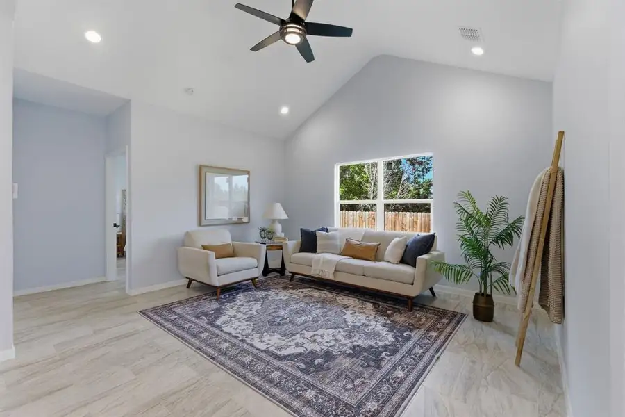 Living area featuring ceiling fan, recessed lighting, and a high ceiling Living area featuring ceiling fan, recessed lighting, and a high ceiling