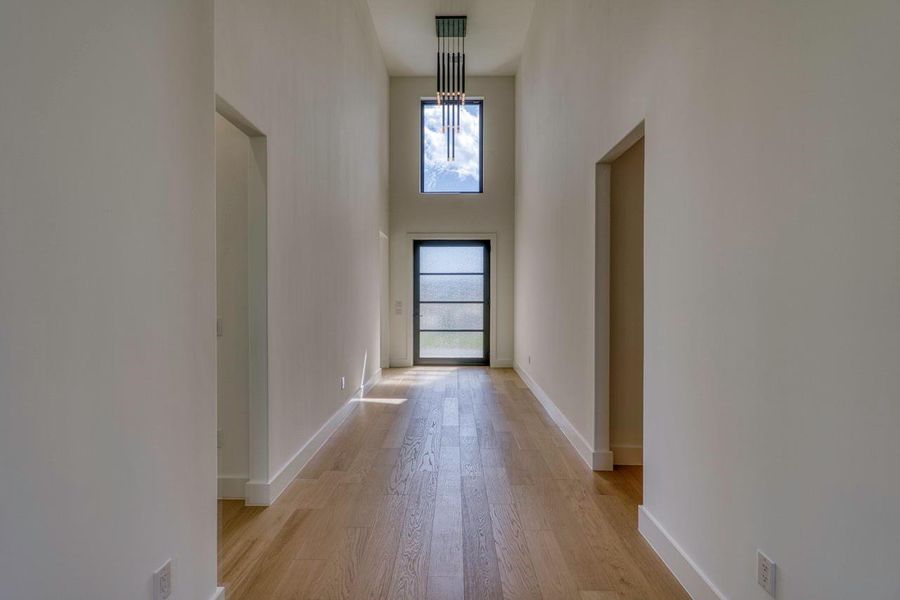 Soaring ceilings and light wood floors create an immediate sense of scale upon entry.