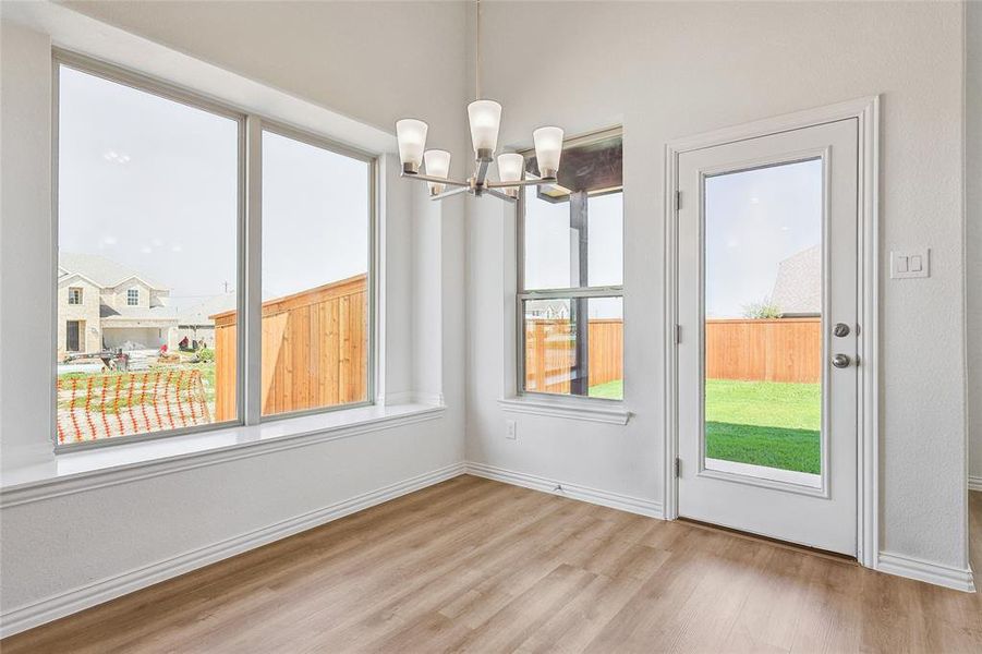 Unfurnished dining area featuring light hardwood / wood-style flooring and a notable chandelier