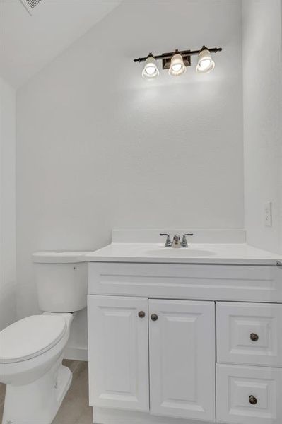 Half bath featuring vanity and toilet