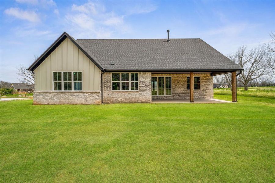 Rear view of property featuring a yard and a patio area