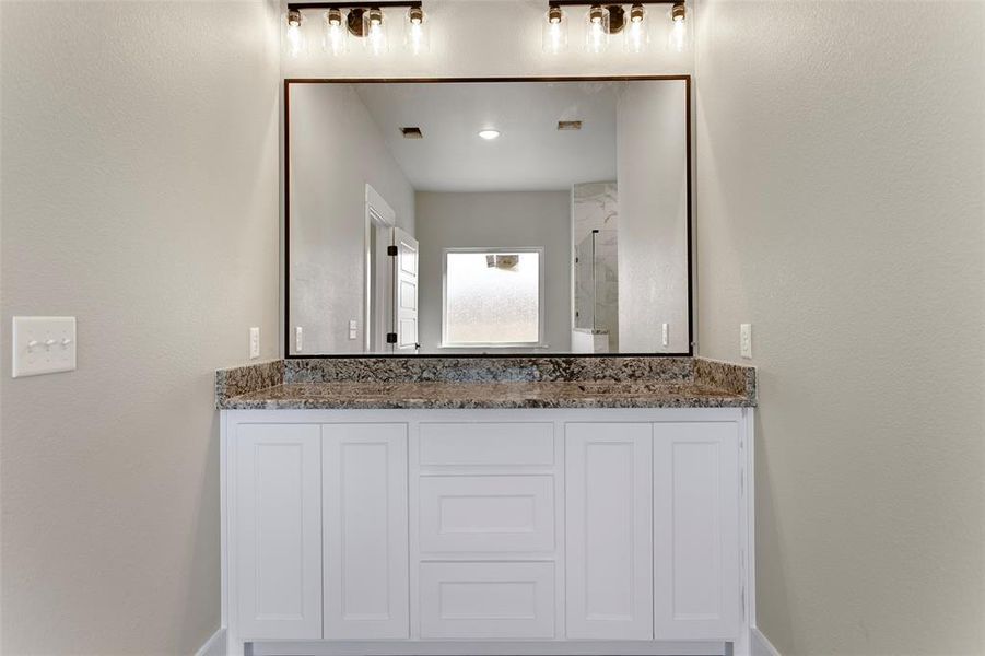 Bathroom featuring vanity and a shower