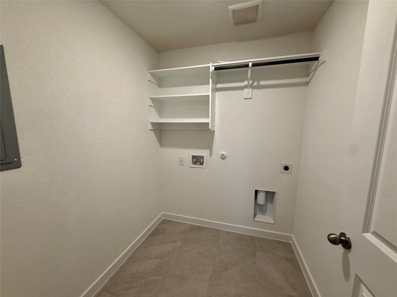 Washroom featuring gas dryer hookup, hookup for an electric dryer, hookup for a washing machine, electric panel, and light tile patterned floors Washroom featuring gas dryer hookup, hookup for an electric dryer, hookup for a washing machine, electric panel, and light tile patterned floors